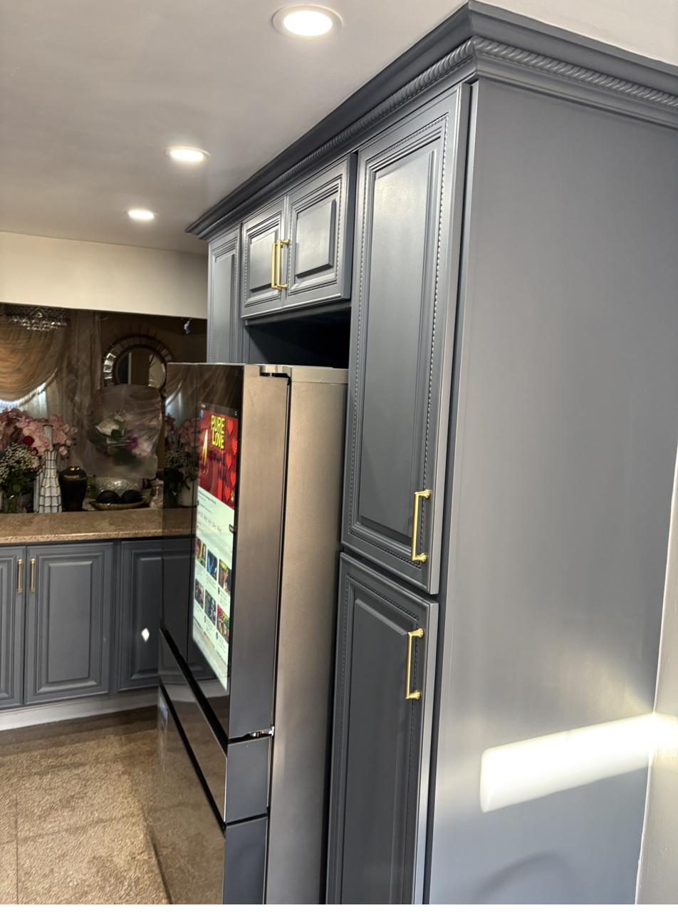 Slate gray kitchen cabinets with gold hardware and crown molding