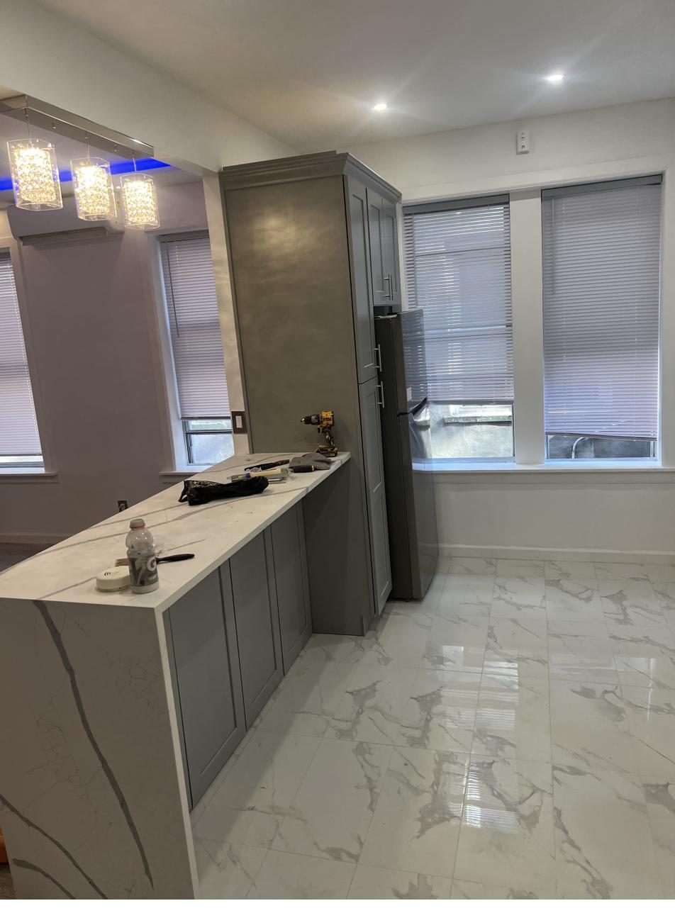 Kitchen with marble waterfall island and large-format floor tile