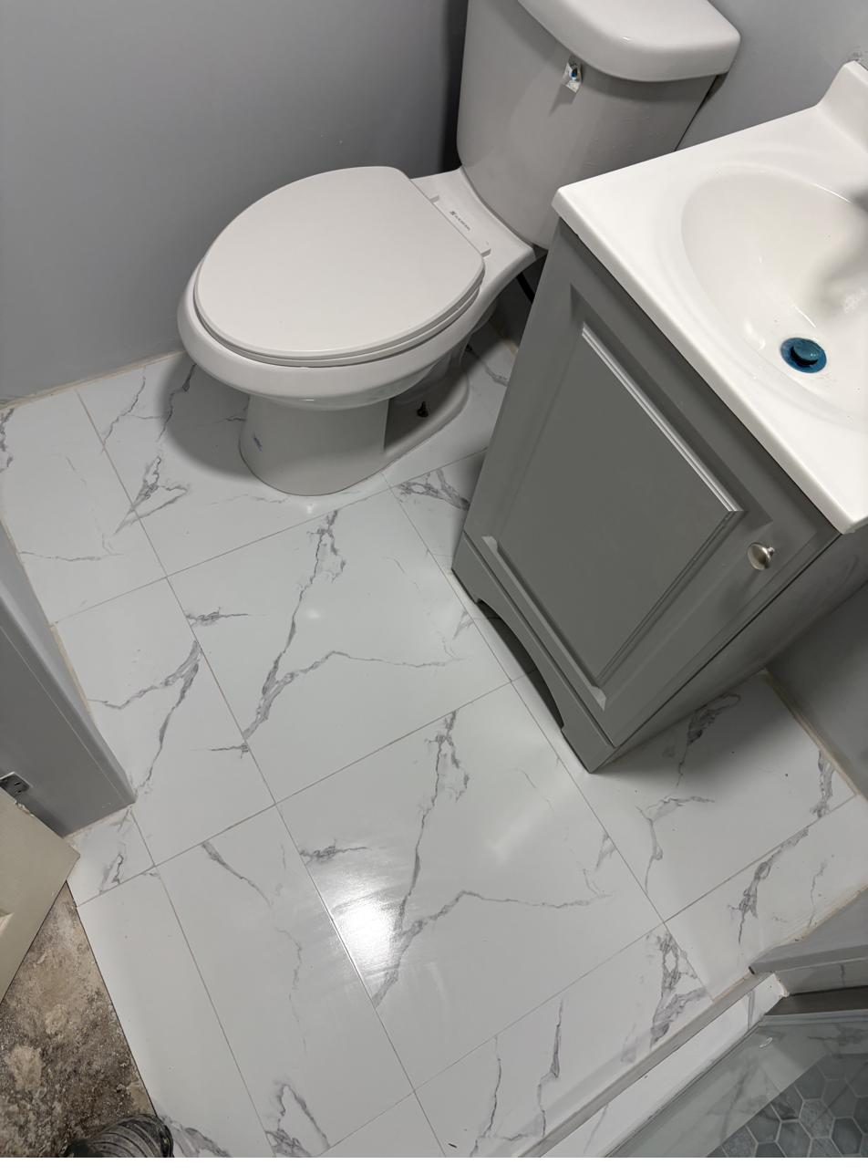 Finished half bath with marble-look tile floor